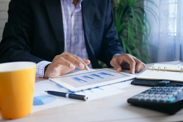 Persona revisant les finances empresarials en una tableta